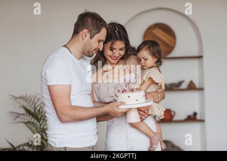 Genitori e figlia festeggiano il compleanno a casa Foto Stock