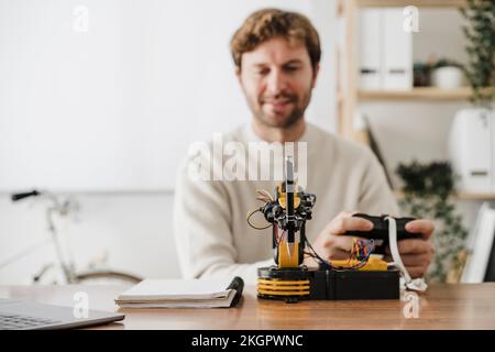 Ingegnere che utilizza il modello robotico braccio che tiene la penna sulla scrivania in ufficio Foto Stock