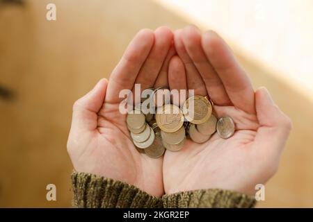 Mani di giovane uomo che tiene le monete Foto Stock