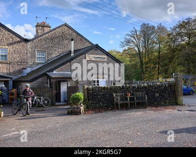 Il ciclista maschile adulto si prepara a montare il suo ciclo fuori dalla sala da tè PuddleDucks, Dunsop Bridge, Lancaster Foto Stock