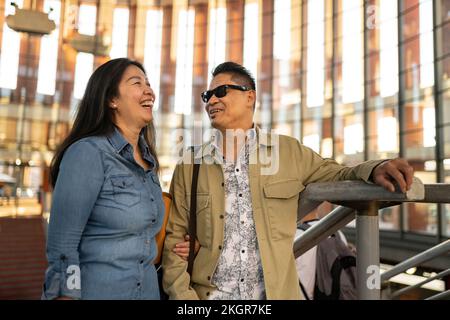 Coppia matura felice che parla l'un l'altro da ringhiera Foto Stock