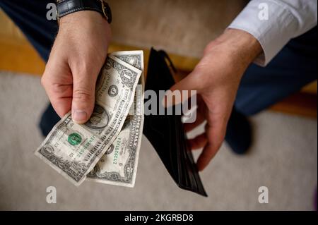 Man holding US dollar bills and wallet Foto Stock