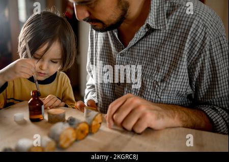 Padre e figlio che fanno giocattoli di legno a casa Foto Stock