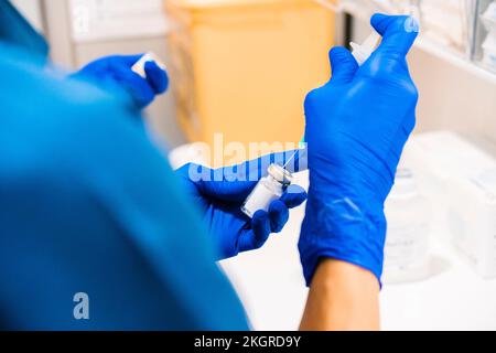 Mani dell'infermiere che preparano la siringa presso la clinica medica Foto Stock