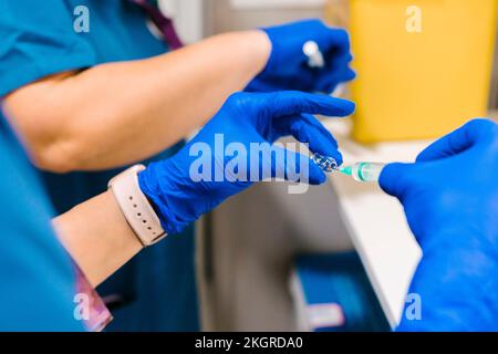 Mani dell'infermiere che preparano la siringa in ospedale Foto Stock