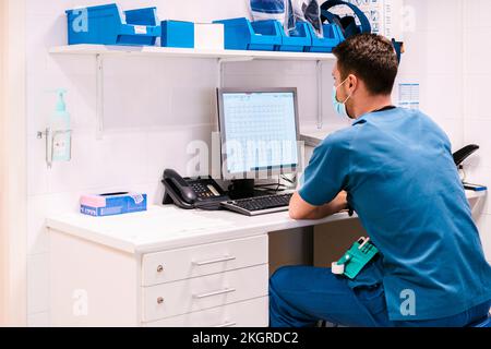 Medico che lavora al computer alla scrivania in ospedale Foto Stock