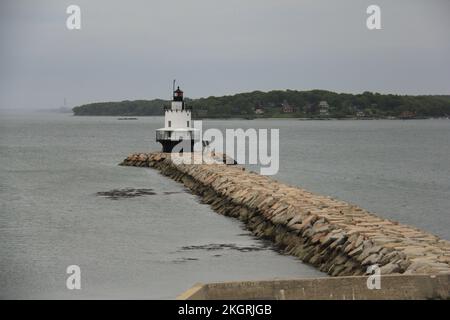 Un passaggio pedonale in molo per il Bug Light (Spring Point Ledge Lighthouse) con un'isola alberata sullo sfondo Foto Stock