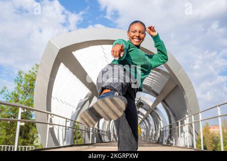 Giovane donna spensierata che balla sulla passerella Foto Stock