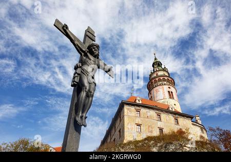 Repubblica Ceca, Regione della Boemia Meridionale, Cesky Krumlov, scultura di Gesù crocifisso con il Castello di Cesky Krumlov Foto Stock