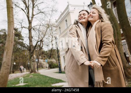 Madre e figlia sorridenti in piedi con guancia a guancia Foto Stock