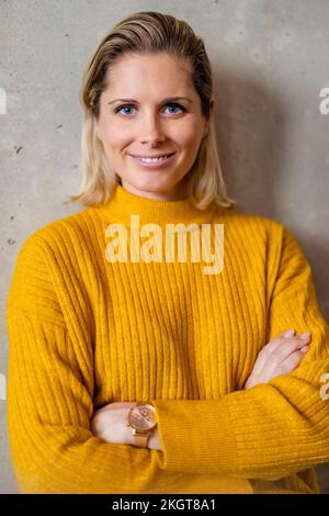 Donna d'affari sicura che indossa un maglione giallo Foto Stock