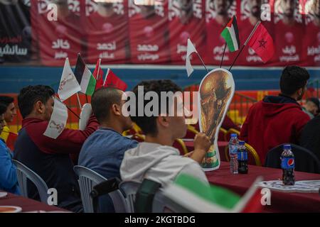 Gaza, Palestina, Stati Uniti. 23rd Nov 2022. (INT) i palestinesi sostengono la squadra di calcio marocchina durante la partita contro la Croazia nella Coppa del mondo FIFA in Qatar. 23 novembre 2022, Gaza, Palestina: Centinaia di palestinesi nella striscia di Gaza sono stati nella Saad Sail Hall della striscia di Gaza per sostenere e incoraggiare la squadra arabo-marocchina a giocare contro la Croazia durante la Coppa del mondo di calcio FIFA 2022 in Qatar. Il gioco si è concluso tra il 0 e il 0, un pareggio e il vice ambasciatore Qatari Khaled al-Hardan hanno condiviso l'atmosfera entusiastica con i fan mentre guardavano la partita. Credit: Saher Elghorra/Thenews2 (Credit Image: © Sahe Foto Stock