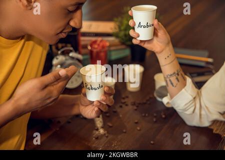 Giovane inalando l'aroma di una bevanda caffeinata Foto Stock