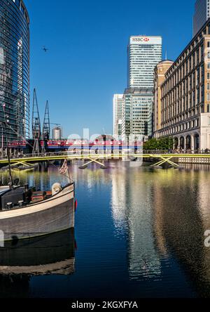 Canary Wharf a West India Docks con chiatta in primo piano e HSBC & Banks edifici. West India Quay DLR Crossrail stazione della metropolitana dietro Londra E14 Foto Stock