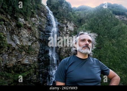 Uomo sotto la cascata di Froda a Sonogno, Svizzera Foto Stock