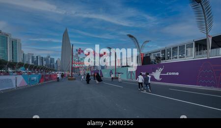 Foto al tramonto sulla Corniche di Doha che mostra la preparazione del Qatar per la Coppa del mondo FIFA Qatar 2022 con gente del posto e visitatori che camminano sul lungomare Foto Stock