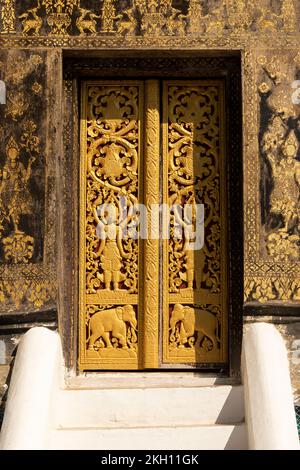 Porta dorata riccamente decorata con rilievi, al tempio Wat Xieng Thong, a Luang Prabang, Laos Foto Stock