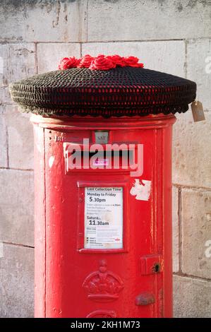 Un cappello di lana lavorato a maglia nera copre una scatola di colonne rosse. Commemorando la triste morte della Regina Elisabetta II, il più lungo monarca regnante della storia britannica. Foto Stock