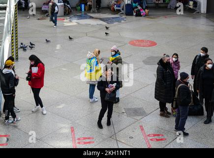 Persone provenienti dall'Ucraina si trovano nella sala degli arrivi della stazione centrale di Monaco. Sono in attesa di aiuto. Foto Stock