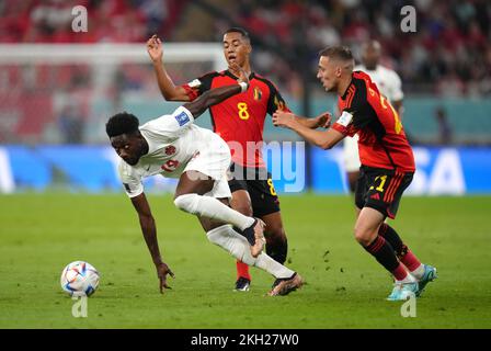 Alphonso Davies (a sinistra) del Canada e Timothy Castagne (a destra) del Belgio e Youri Tielemans si battono per la palla durante la partita di Coppa del mondo FIFA Group F allo stadio Ahmad bin Ali, al Rayyan. Data immagine: Mercoledì 23 novembre 2022. Foto Stock