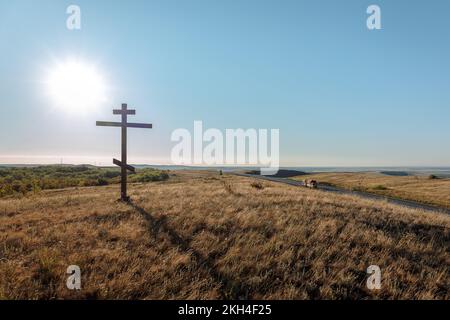 Una croce cristiana sulla collina. Mattina presto all'alba in estate. Alba con cielo blu. Foto di alta qualità Foto Stock