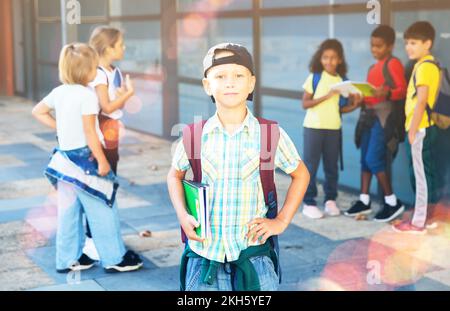 Tweenager sicuro che posa vicino a scuola durante la pausa tra le lezioni Foto Stock