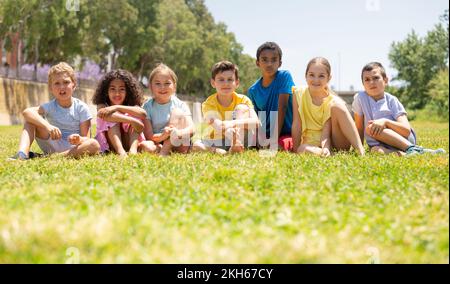 Gruppo di bambini felici su erba verde nel parco Foto Stock