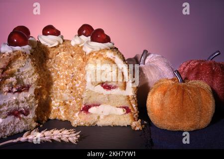 Torta tedesca Frankfurter Kranz o torta della corona di Francoforte. Bisquit con crema al burro e ciliegie. Tagliare metà della torta. Arredamento autunnale. Foto Stock