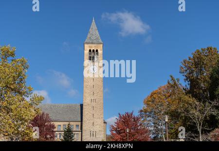 Ithaca, New York-24 ottobre 2022: McGraw Tower con un cielo blu e uno sfondo fogliare autunnale nel campus della Cornell University Foto Stock