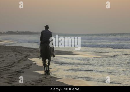 Gaza, Palestina. 23rd Nov 2022. Un uomo palestinese cavalca un cavallo al tramonto lungo la spiaggia di Gaza. (Foto di Mahmoud Issa/SOPA Images/Sipa USA) Credit: Sipa USA/Alamy Live News Foto Stock