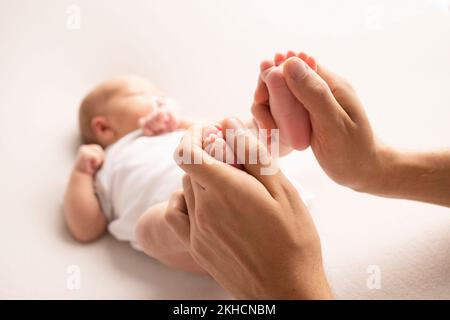 La madre sta facendo il massaggio sul suo piede del bambino. Prevenzione dei piedi piatti, sviluppo, tono muscolare, displasia. Foto Stock