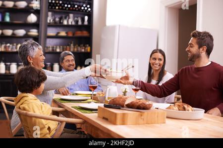 Questa famiglia ha tutto, dal cibo all'amore. Una foto di una famiglia felice che condivide un pasto insieme. Foto Stock