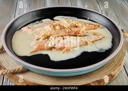 Pesce trota con nocciole e salsa di panna cotta al forno. Cucina francese gourmet. Foto Stock