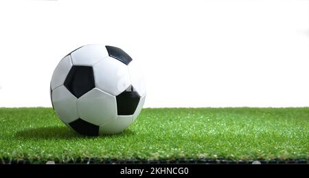 Palla da calcio classica su erba artificiale e sfondo bianco isolato. Composizione orizzontale. Foto Stock