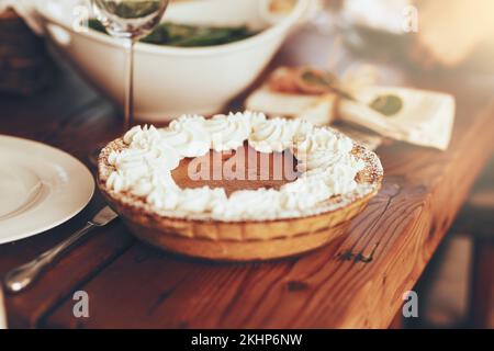 Torta di zucca, cibo e tavolo per il pranzo al tavolo da pranzo in casa. Cene raffinate, torte o dolci a buffet, brunch o festa di ringraziamento, festivi Foto Stock