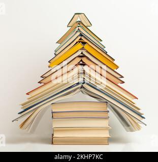 Una pila di libri disposti a forma di albero di Natale. Conoscenza, lettura, hobby. Foto di alta qualità Foto Stock