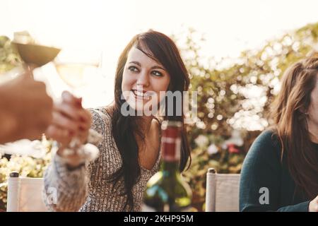 Brindisi, festa e donna con un bicchiere di vino a pranzo in famiglia in un giardino per Natale. Festeggiamenti, festa e ragazza con un drink di alcol, bicchiere di vino Foto Stock