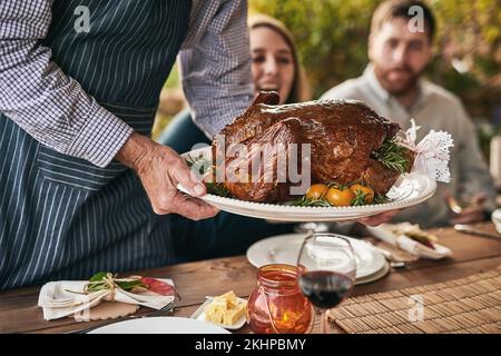 Ringraziamento, tavola e carne arrosto a cena, pranzo o cena in occasione di un evento all'aperto. Natale, riunione e chef che serve la gente un lusso Foto Stock