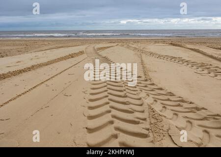 gommisti su una spiaggia sabbiosa che conduce al mare Foto Stock