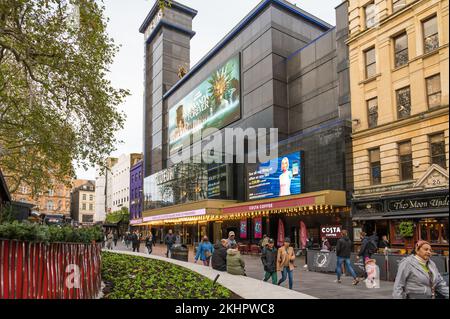 Le persone che si trovano a Leicester Square passano davanti al cinema Odeon Luxe. Londra, Inghilterra, Regno Unito Foto Stock