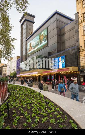 Le persone che si trovano a Leicester Square passano davanti al cinema Odeon Luxe. Londra, Inghilterra, Regno Unito Foto Stock