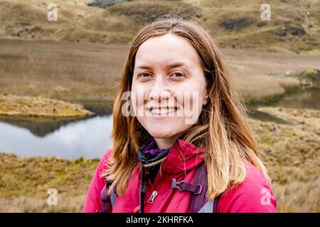Primo piano foto orizzontale di una donna sorridente escursionista nel Parco Nazionale di Cajas negli altopiani dell'Ecuador, Cuenca, Ande tropicali. Foto Stock