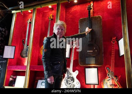 24 novembre 2022, Amburgo: Uli Salm, ospite celebrità e musicista rock, mostra il basso ' lo Zwick Pö', realizzato da un tavolo nello Zwick Pöseldorf, nella Zwick St Pauli. Il chitarrista Jens Ritter presenta alcuni dei suoi strumenti al pub di culto 'Zwick' di Amburgo-St Pauli. Le chitarre elettriche e i bassi di Ritter sono acquistati non solo da musicisti ma anche da collezionisti e musei; i suoi strumenti sono esposti anche al Metropolitan Museum of Art (New York) allo Smithsonian American Art Museum (Washington, DC) e al Technoseum (Mannheim). Foto: Marcus Brandt/dpa Foto Stock