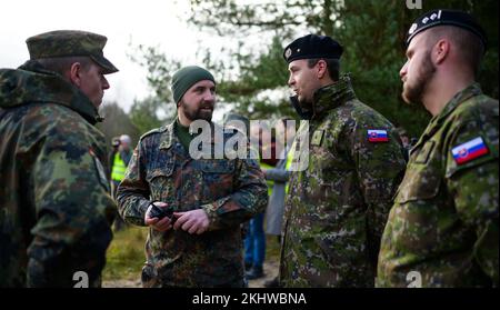 Munster, Germania. 24th Nov 2022. I soldati e gli istruttori di guida delle forze armate tedesche (l e 2nd da sinistra) parlano con i soldati slovacchi durante una pausa. La Bundeswehr sta attualmente addestrando i soldati slovacchi sul carro armato principale di battaglia di Leopard 2 A4 a Munster. Lo sfondo di questo è un anello di scambio di 15 carri armati leopardo alla Slovacchia commissionato dal governo tedesco, come la Bundeswehr ha annunciato giovedì. Credit: Philip Schulze/dpa/Alamy Live News Foto Stock