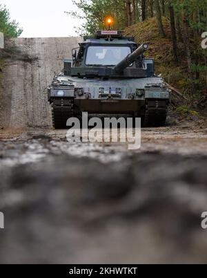 Munster, Germania. 24th Nov 2022. Un soldato slovacco guida un carro armato della Bundeswehr Leopard II, attraverso il terreno durante l'allenamento alla guida. La Bundeswehr sta attualmente addestrando i soldati slovacchi sul carro armato principale di battaglia di Leopard 2 A4 a Munster. Lo sfondo è un anello di scambio di 15 carri armati leopardo alla Slovacchia commissionato dal governo tedesco, la Bundeswehr annunciato Giovedi. Credit: Philip Schulze/dpa/Alamy Live News Foto Stock