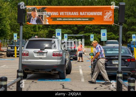 I veterani si iscrivono al parcheggio del negozio di ferramenta con l'anziano che passa Foto Stock
