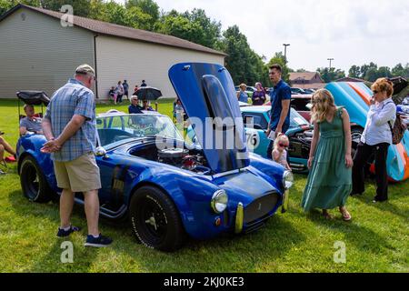 Le persone ispezionano una replica blu di auto sportiva AC Shelby Cobra 427 in mostra a Fort Wayne, Indiana, USA. Foto Stock