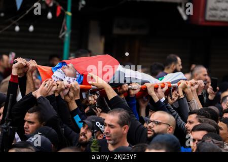 Nablus, Cisgiordania, Palestina. 24th Nov 2022. Nablus Cisgiordania, Palestina. 24 novembre 2022. I membri armati del gruppo Lions Den partecipano ai funerali di Mohammad Herzallah, 30 anni, e di Muhammad Abu Kishk, 22 anni, nella città di Nablus in Cisgiordania. Mohammad Herzallah, è morto per gravi ferite nella testa dopo essere stato ucciso dalle forze israeliane durante un raid militare in cui il palestinese Ibrahim Nabulsi è assassinato lo scorso agosto. Mohammed Abu Kishk morì anche per i suoi danni dopo essere stato colpito nell'addome da una pallottola in tensione durante un'incursione militare israeliana nel sito della tomba di Giuseppe a Nablus, sulle Tues Foto Stock