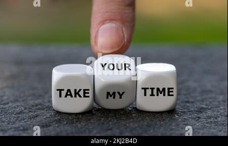 La mano gira i dadi e cambia l'espressione 'Take my time' in 'Take your time'. Foto Stock