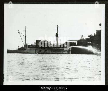 Progetto 18 - attività di test Operation Crossroads (Bikini). Spruzzatura di rimorchiatore dalla nave. Fotografie di Atmospheric Nuclear Testing a Pacific Island e Nevada Test Sites. Foto Stock